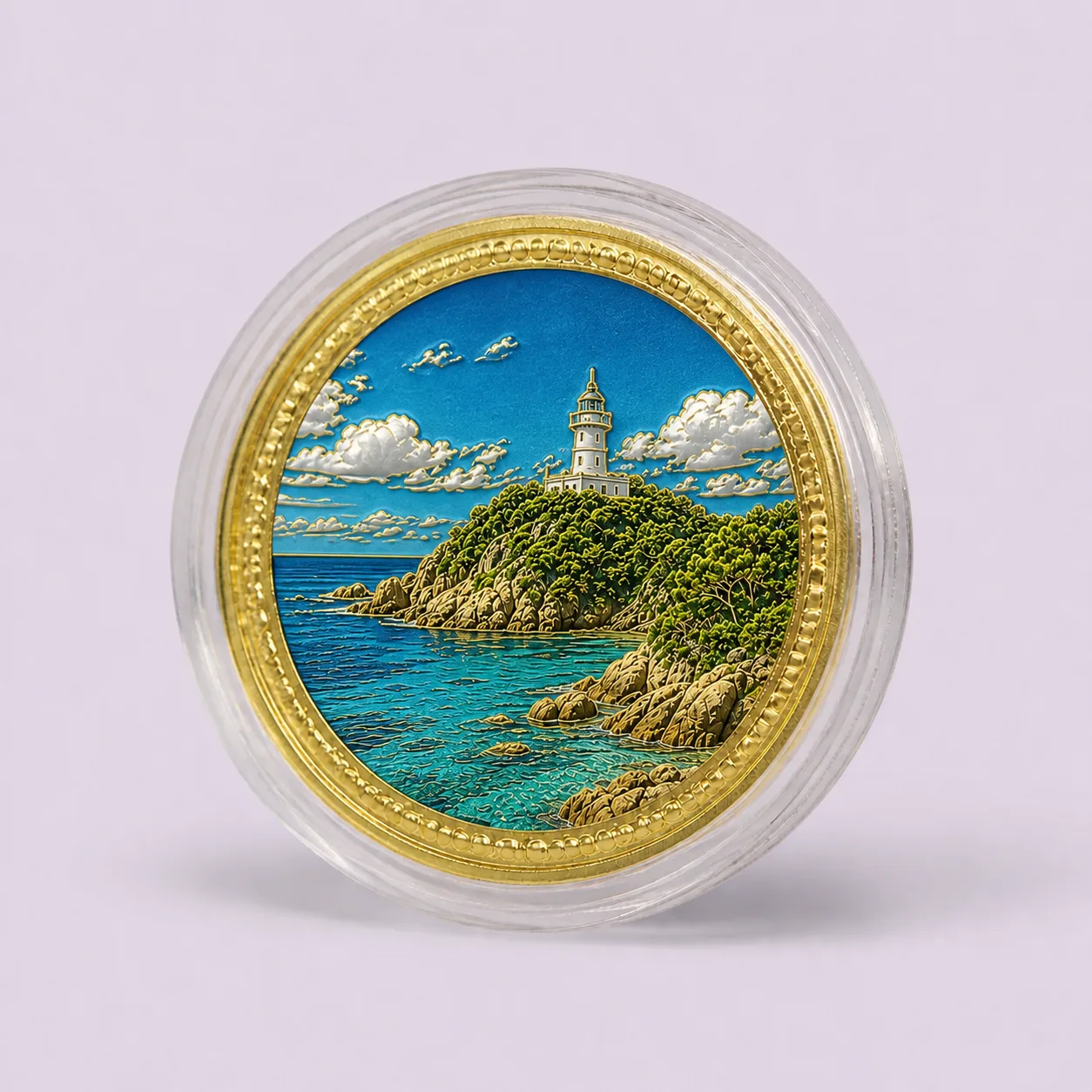 Gold souvenir medallion with raised coastal lighthouse artwork in a clear round capsule