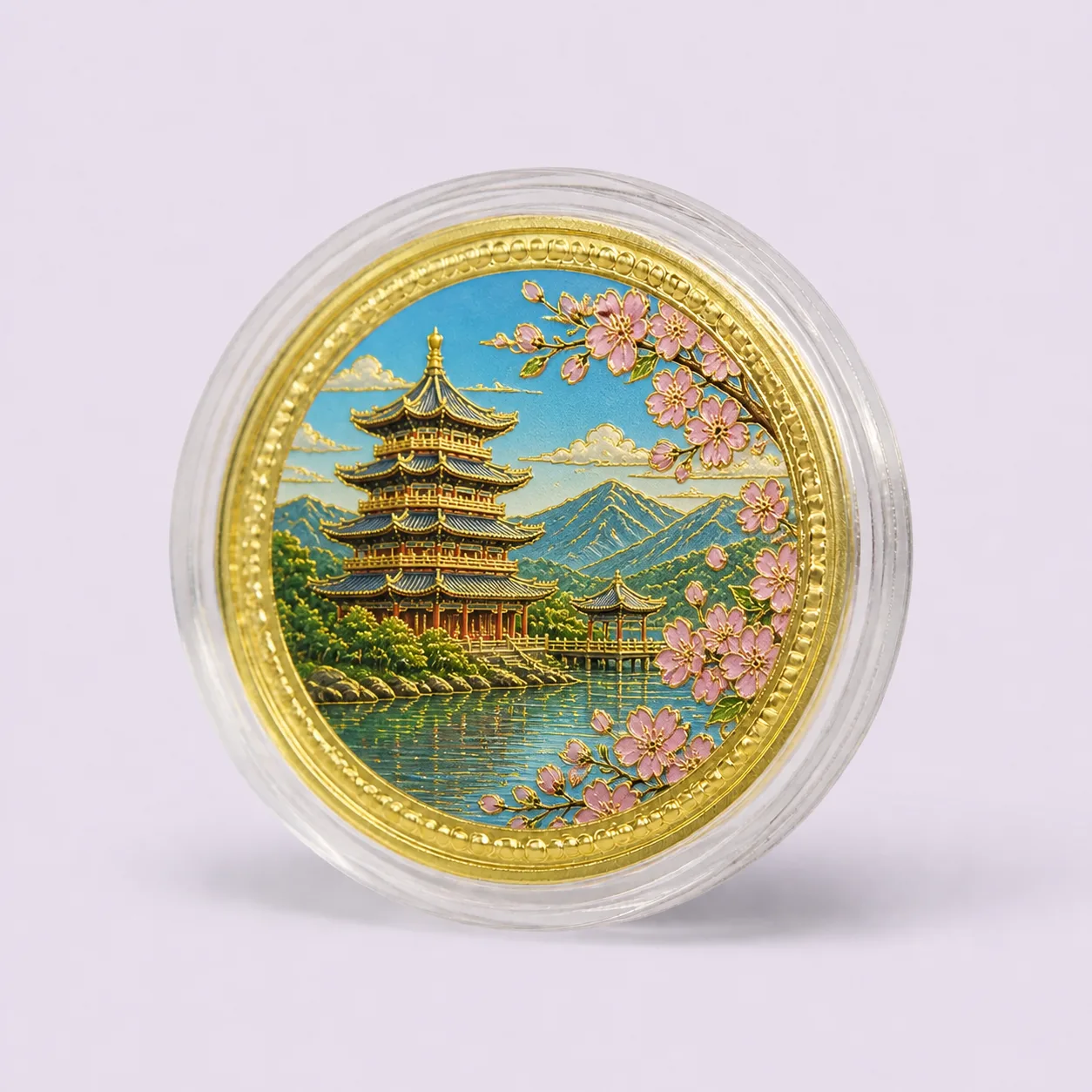 Gold souvenir medallion with raised pagoda and lake artwork in a clear round capsule